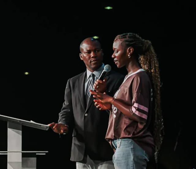 Pastor and youth at podium at AYAC USA